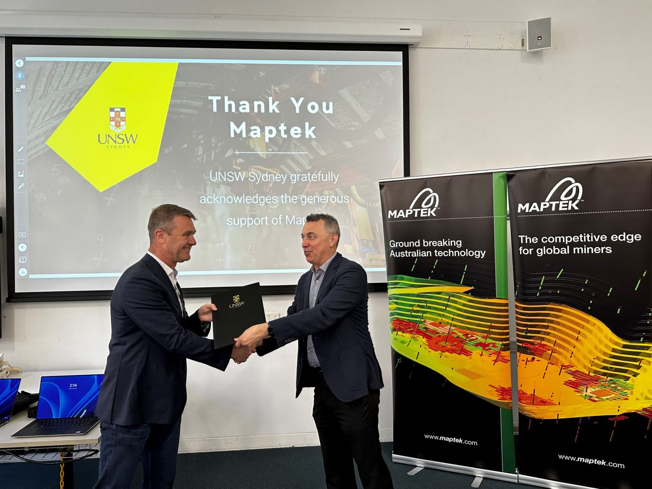 Maptek chairman Peter Johnson receiving the donation acknowledgement from UNSW Professor Maurice Pagnucco.