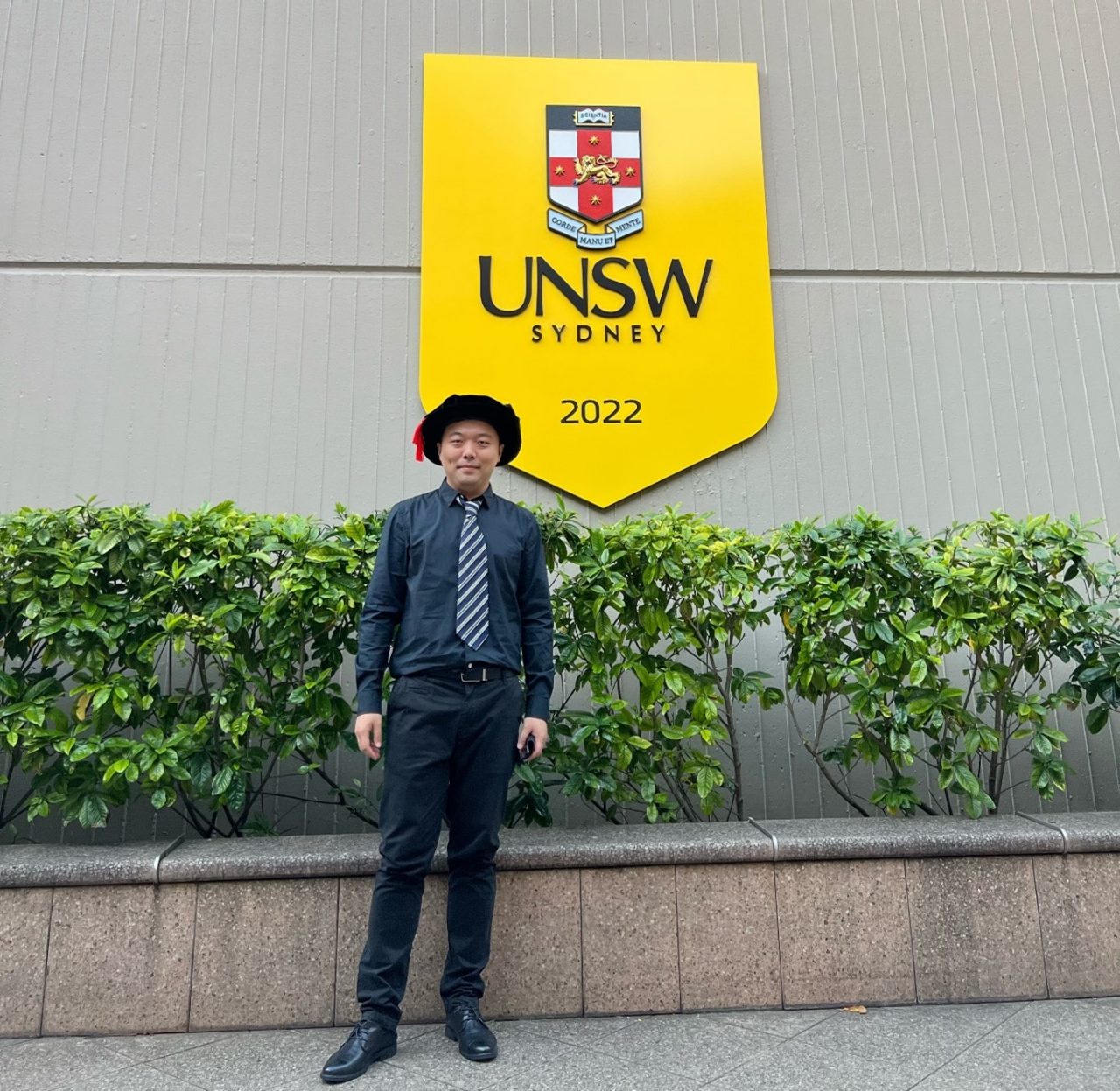 Xia Chen standing in front of UNSW sign