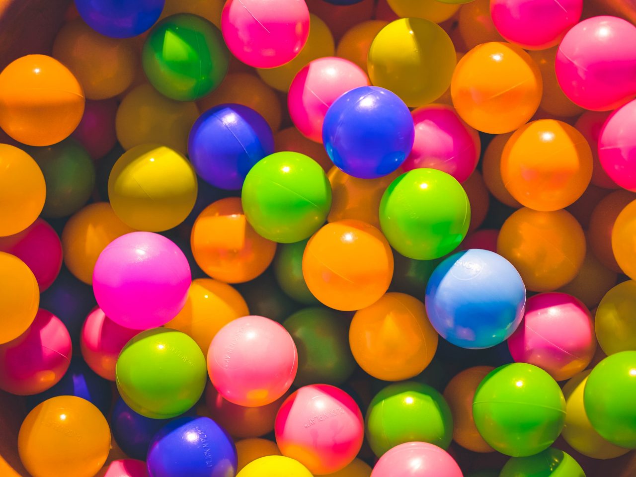 Small bright-coloured balls in a ball pit 