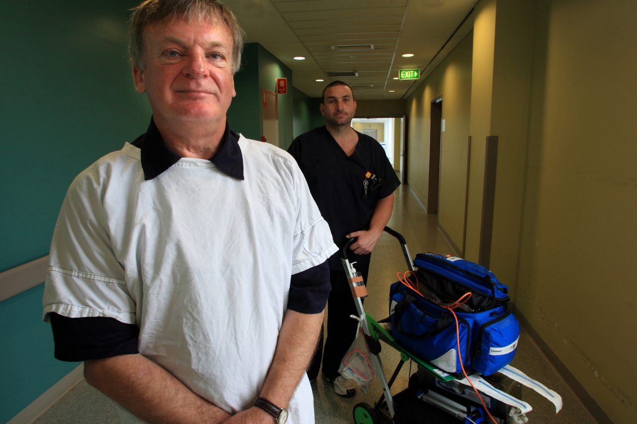 Professor Ken Hillman standing with healthcare worker and MET trolley