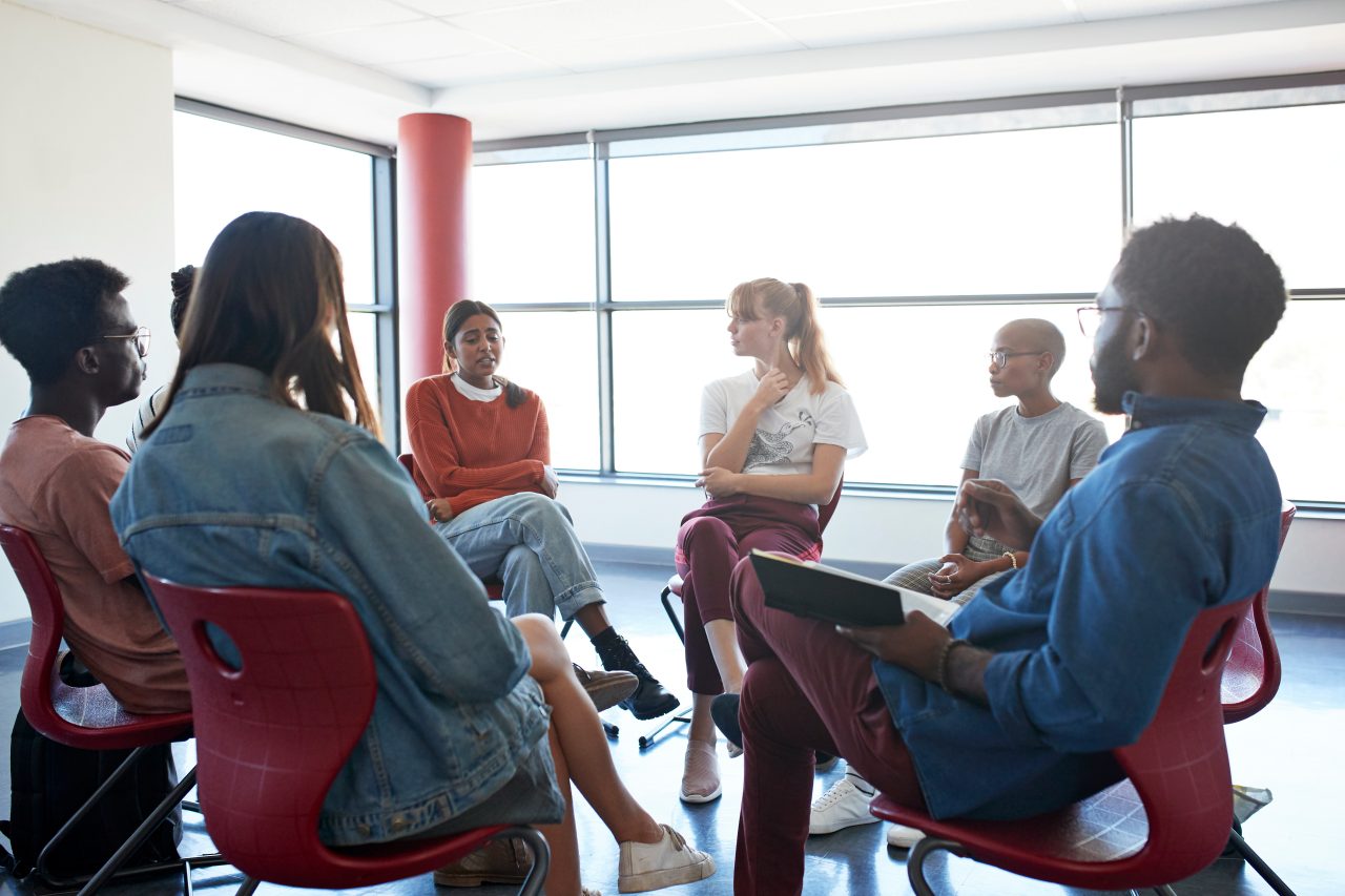 A group of people sitting down in a group treatment session