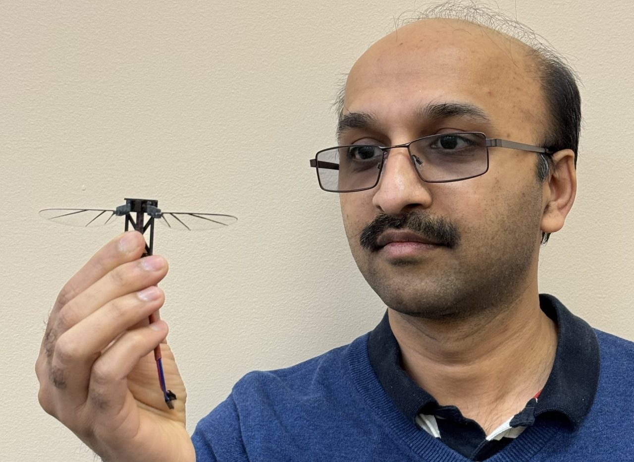Dr Shantanu Bhat from UNSW Canberra holding a insect-style micro drone model.