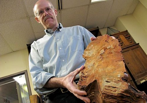 In this Jan. 22, 2013 photo University of Wisconsin-Madison Geoscientist Clark Johnson holds what he says is a 3.5 billion year old rock in Madison, Wis.  Johnson is leading a team of scientists and others studying Earth rocks that are billions of years old looking for crucial information to understand how life might have arisen elsewhere in the universe and guide the search for life on Mars one day.  (AP Photo/Carrie Antlfinger)