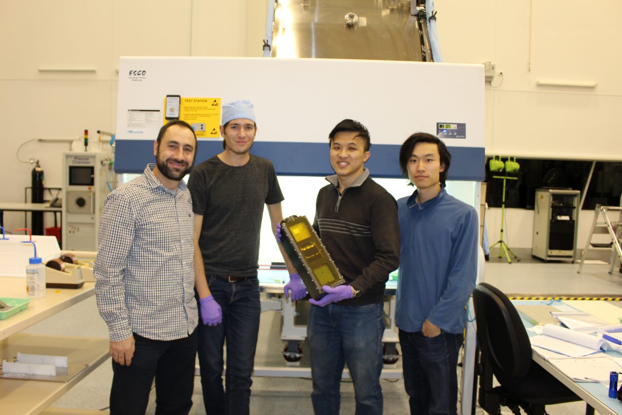 group photo of students and Elias holding the cubesat