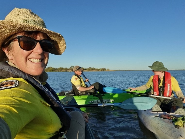 Three researchers in kayaks on a lake