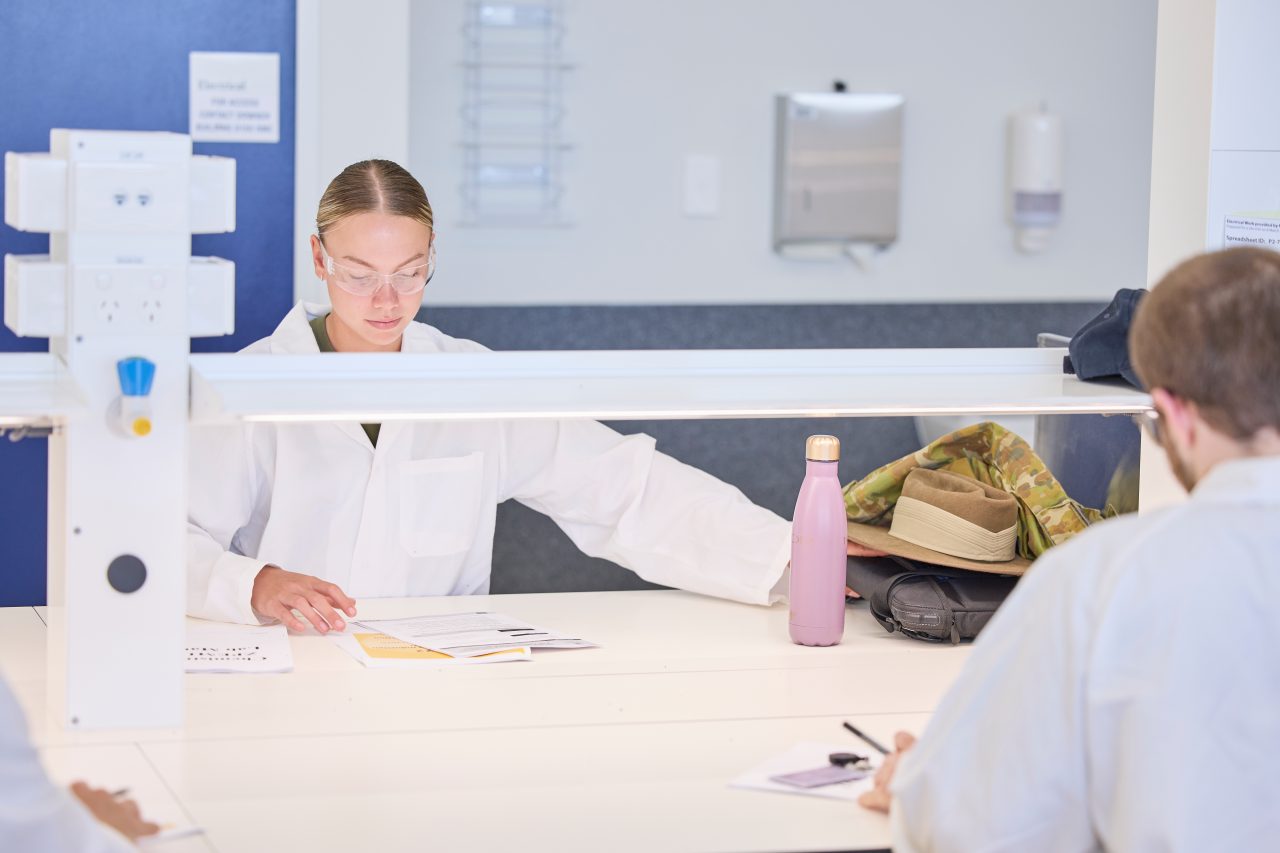 Female student reads notes in a chemistry lab