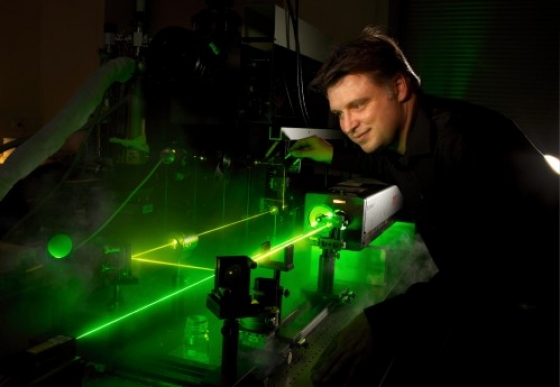 Clemens Ulrich standing infront of a green laser