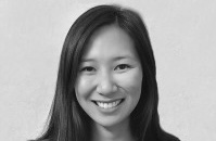 Black and white portrait of Dr. Linda Truong with long straight hair, wearing a floral blouse and a necklace, standing in front of a neutral backdrop.
