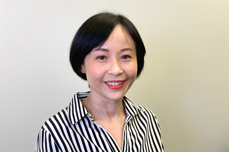 Smiling Dr. Pei Chen with a short black bob haircut, wearing a black-and-white striped blouse, in front of a soft neutral background.