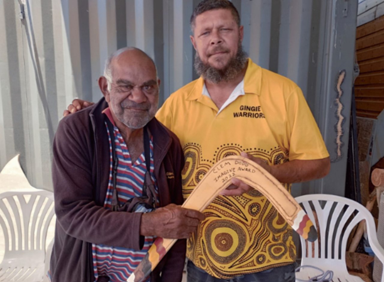 Dharriwaa Elders Group Speaker Clem Dodd being presented with a bubarra (fighting boomerang) made by Dealing with Fines Coordinator Stephen 'Bungee' Dennis in honour of receiving the outstanding lifetime achievement award from the Aboriginal Culture Heritage & Arts Association